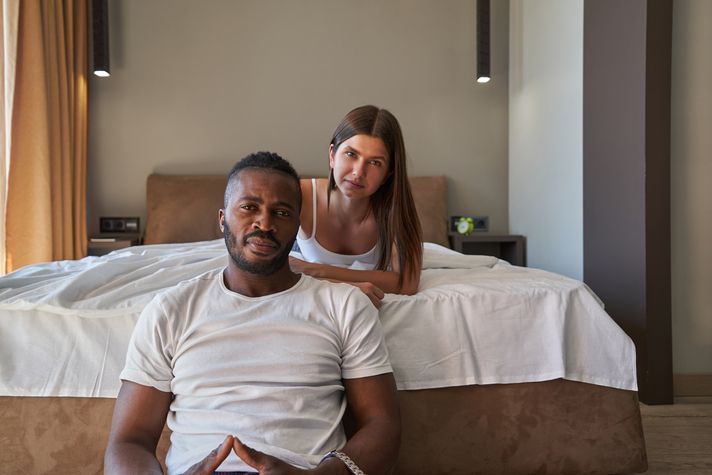 A confident woman teasing a smiling man in a playful, flirty manner, symbolizing the consensual power dynamics of SPH (Small Penis Humiliation) in a lighthearted and enjoyable way