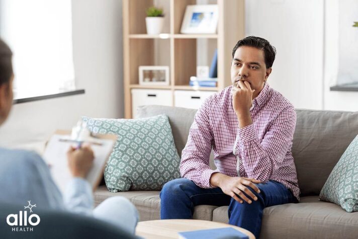 Man sitting Infront of a doctor and understanding the symptoms of Erectile Dysfunction