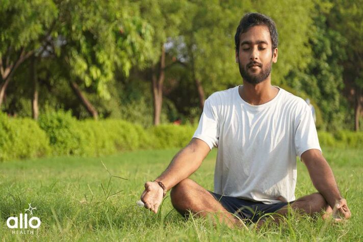 man doing yoga- Man Doing Meditation in Park for preventing Erectile Dysfunction. ling ke liye yoga. brahmacharya benefits in hindi